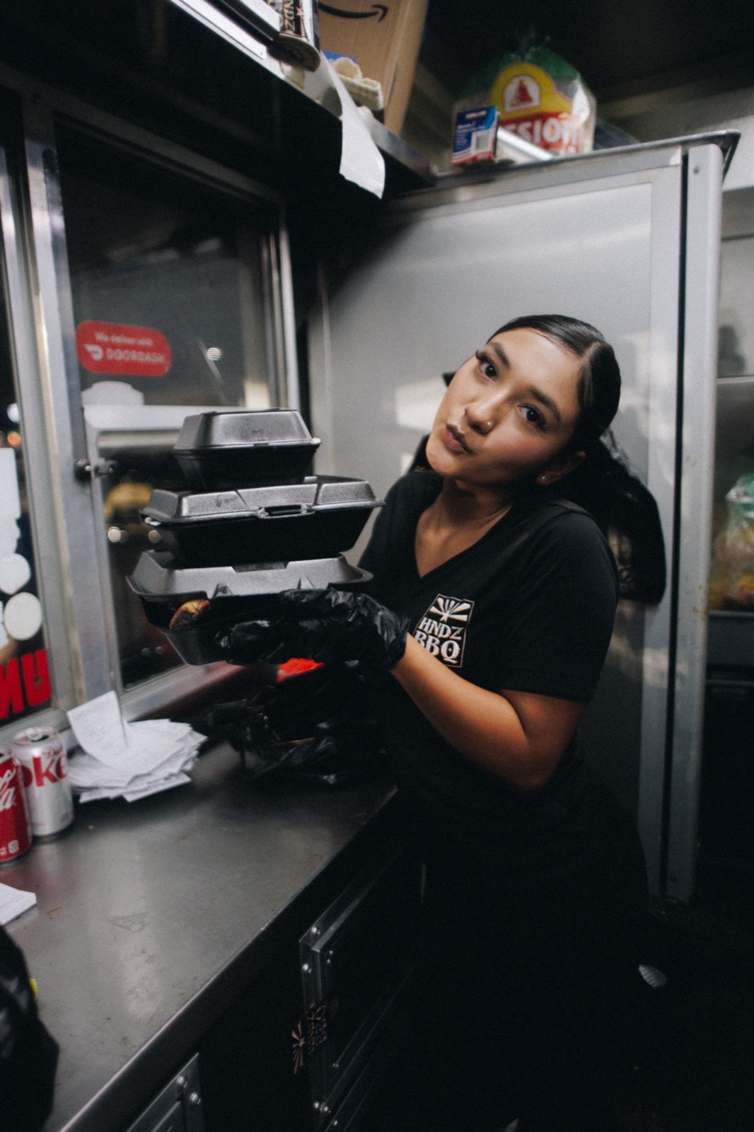 HNDZ BBQ team member preparing takeout orders inside the food truck